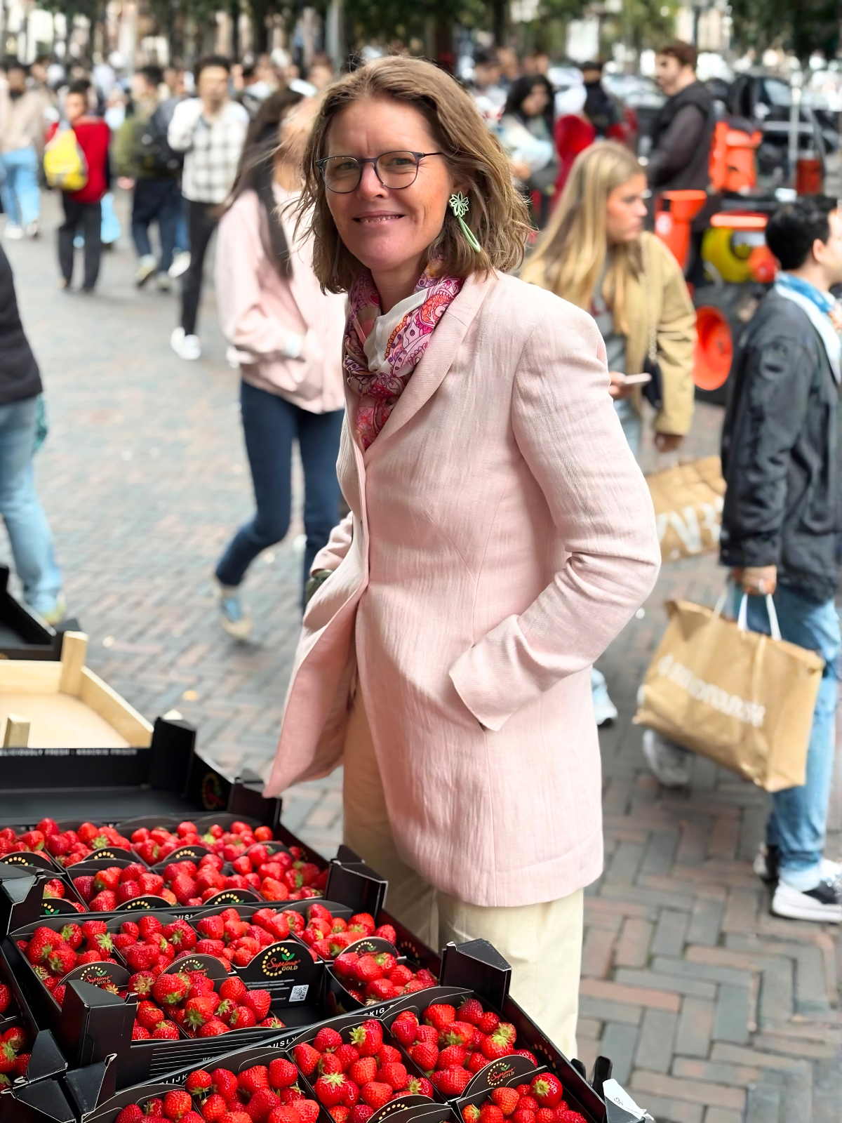 Suzanne Wever op de markt bij kratten met citroenen en aardbeien